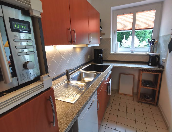 Küche mit Mikrowelle und Geschirrspüler